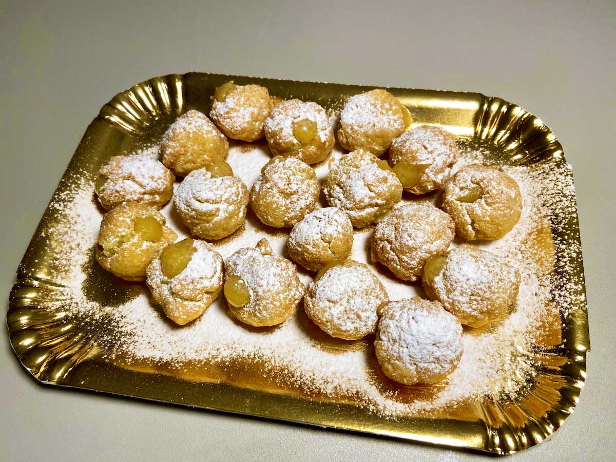 Vassoio pieno di bignè vegani coperti di zucchero a velo