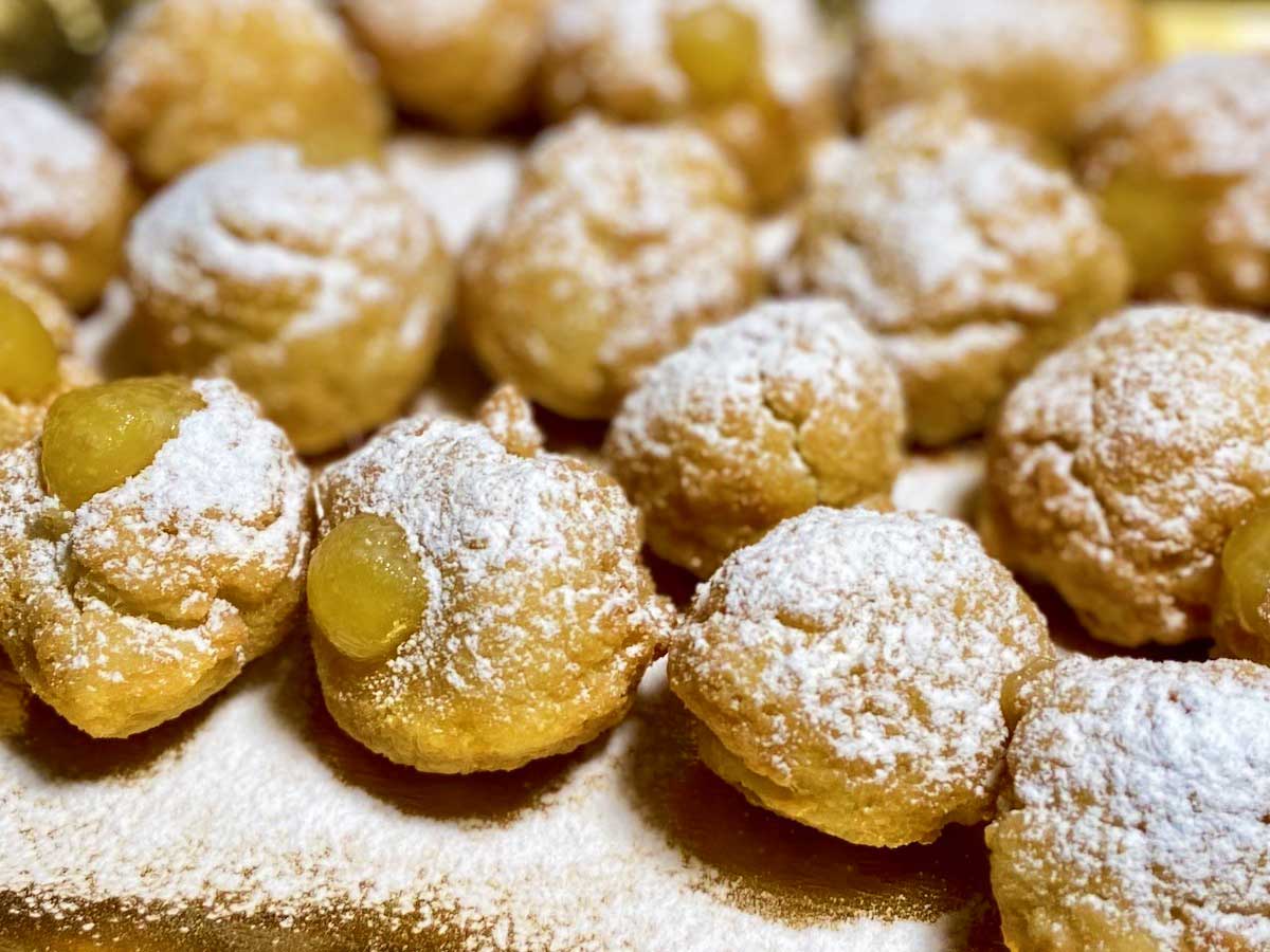 Primissimo piano dei bigné vegani strabordanti di crema all'arancia