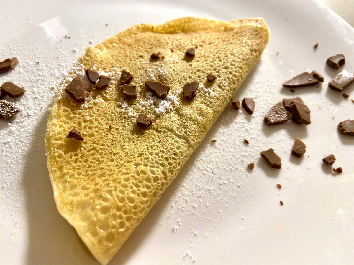 Primissimo piano da tre quarti di una crepes vegana dolce con cioccolato