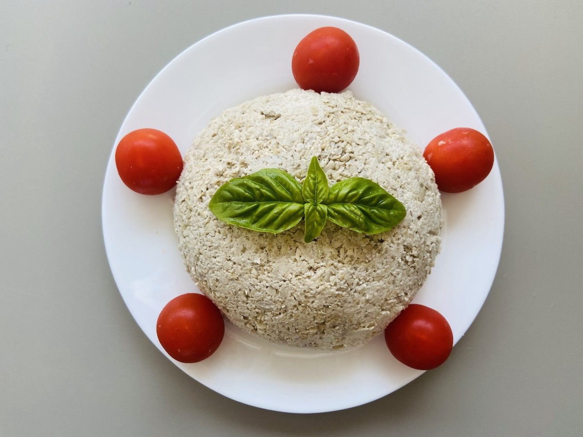 Forma di Formaggio vegano spalmabile con pomodorini e basilico visti dall'alto