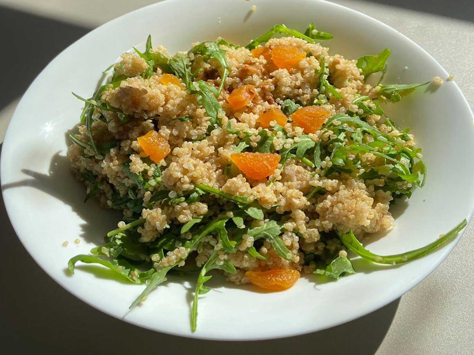 Salsa di sesamo versata sulla quinoa con un cucchiaio