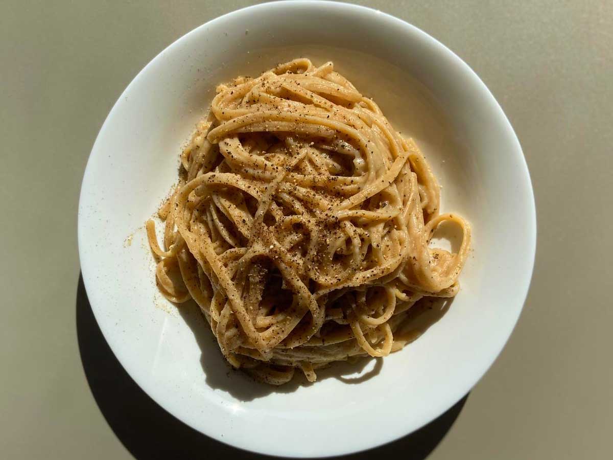 Piatto di pasta burro e parmigiano vegana visto dall'alto