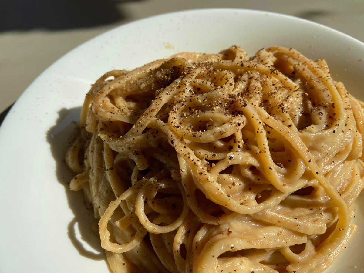 Primissimo piano del piatto di pasta burro e parmigiano vegana