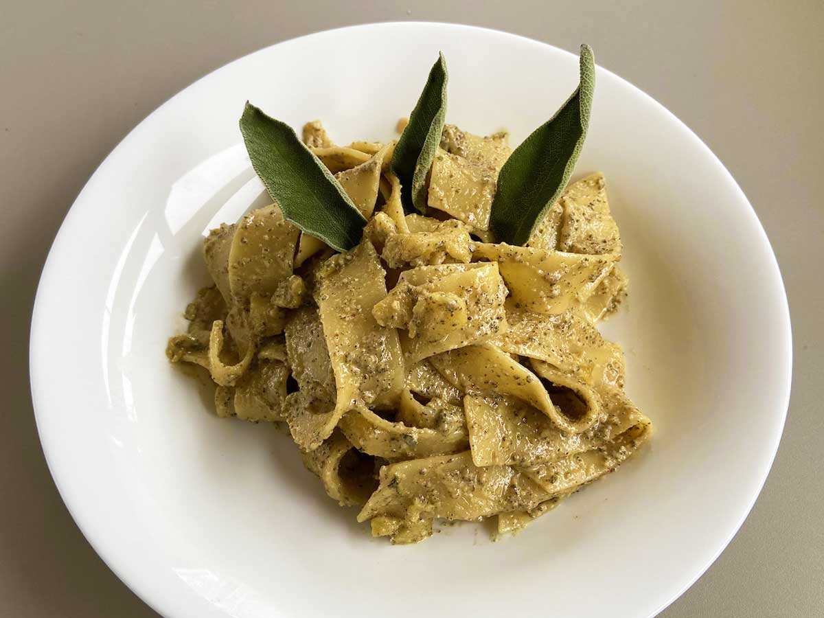 Piatto di pasta con pesto di salvia e mele visto da tre quarti