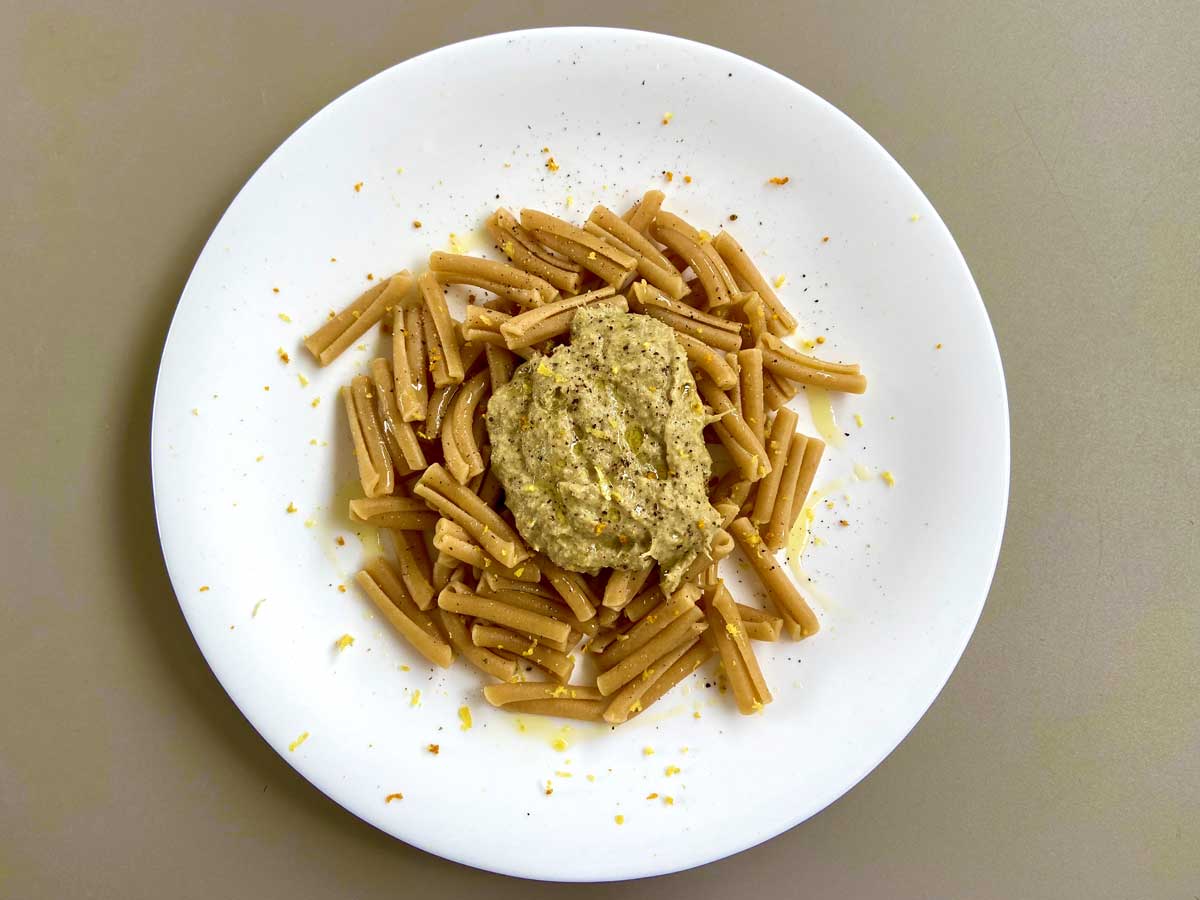 Piatto di pasta con crema di carciofi e limone visto dall'alto