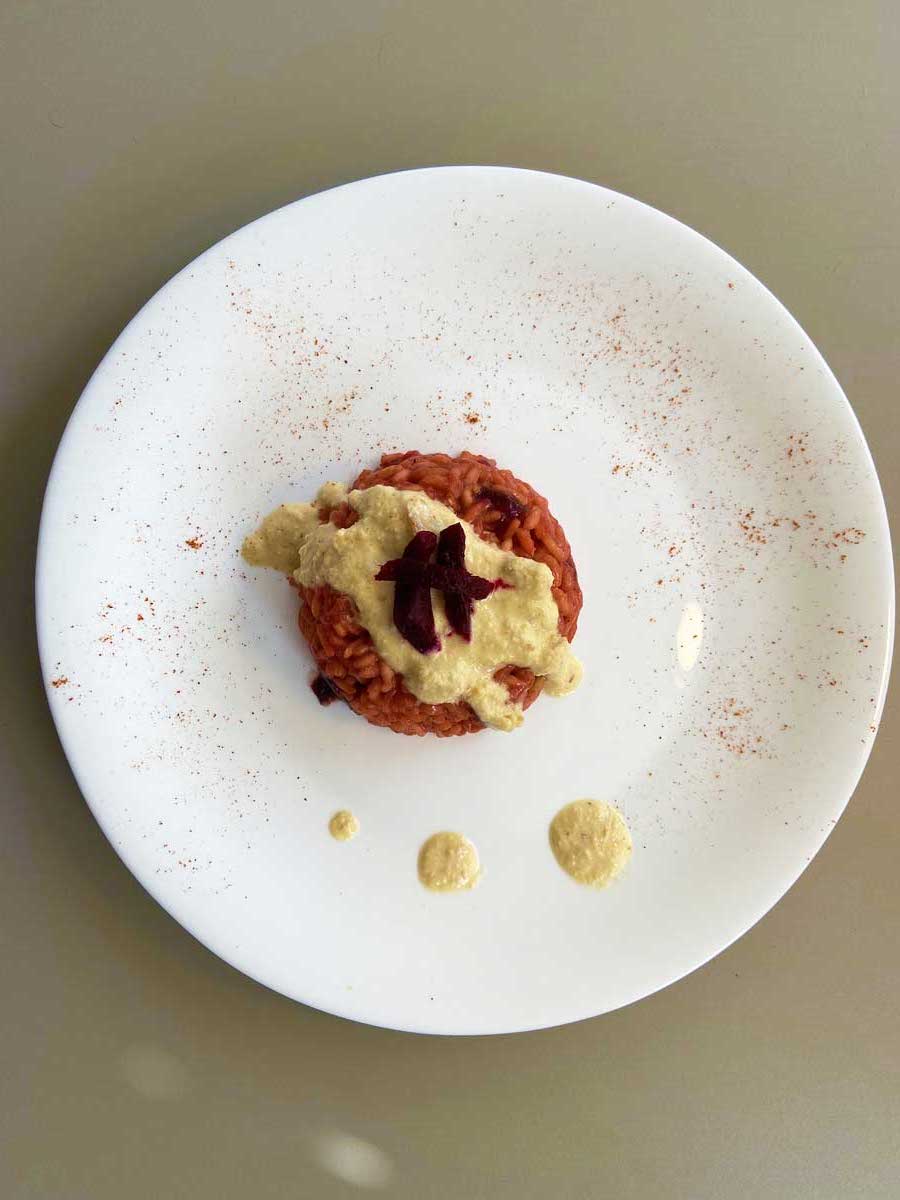 Piatto di risotto alla barbabietola e crema d'arachidi visto dall'alto
