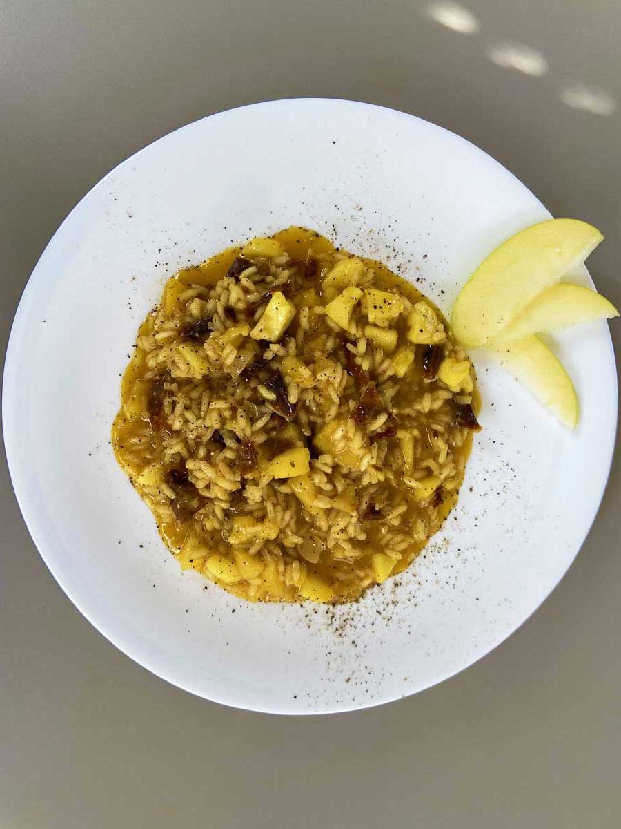 Piatto di risotto mele, zafferano e pomodori secchi visto dall'alto