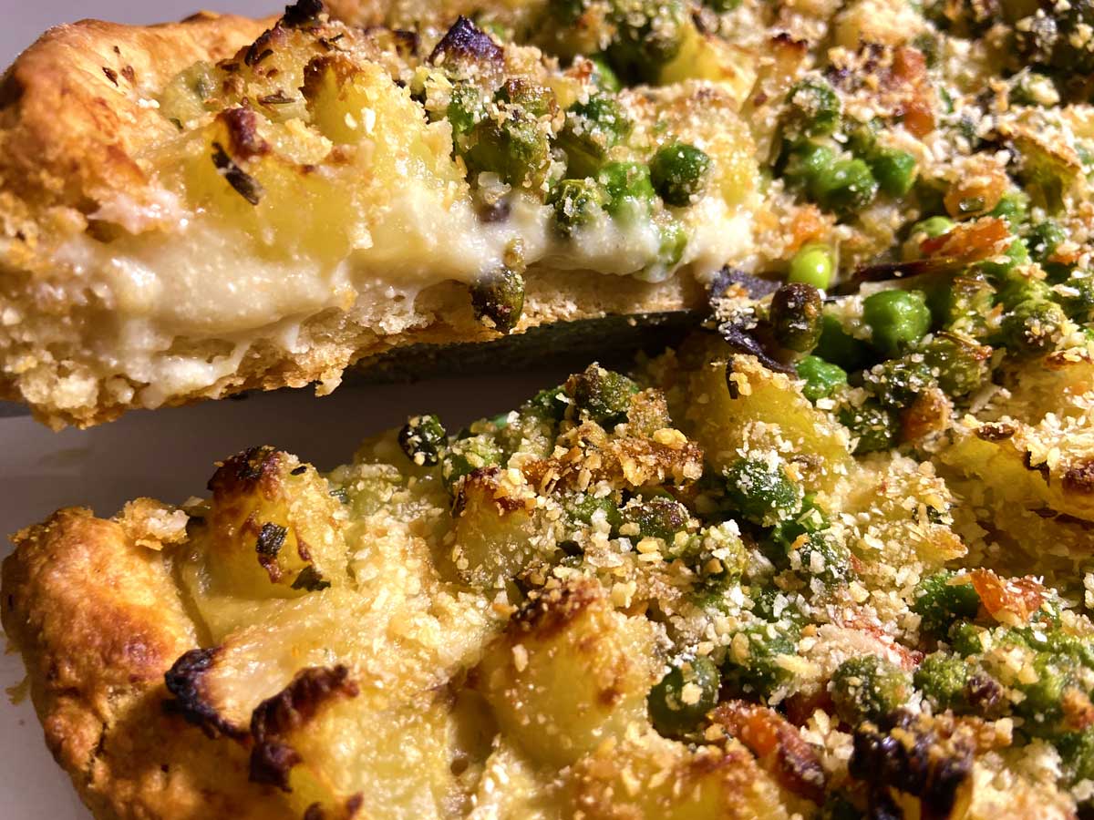 Primissimo piano della torta salata, con la besciamella vegana che cola